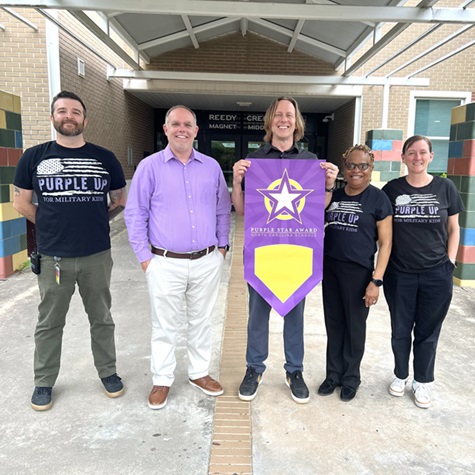  Picture of our admin holding our Purple Up recognition